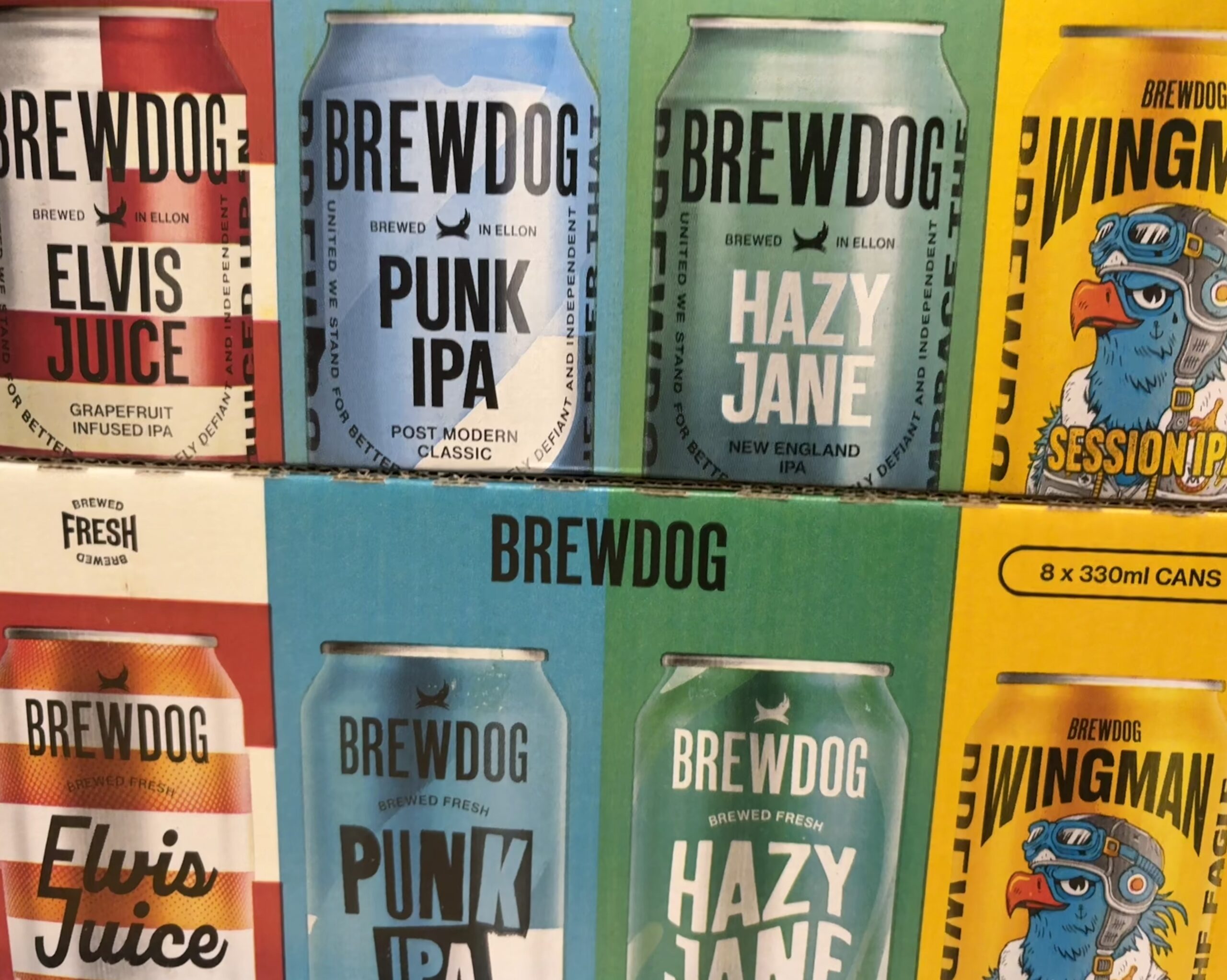 A picture of two packs of BrewDog beer cans stacked on top of each other. Four different types, from left to right, Elvis Juice, Punk IPA, Hazy Jane and Wingman
