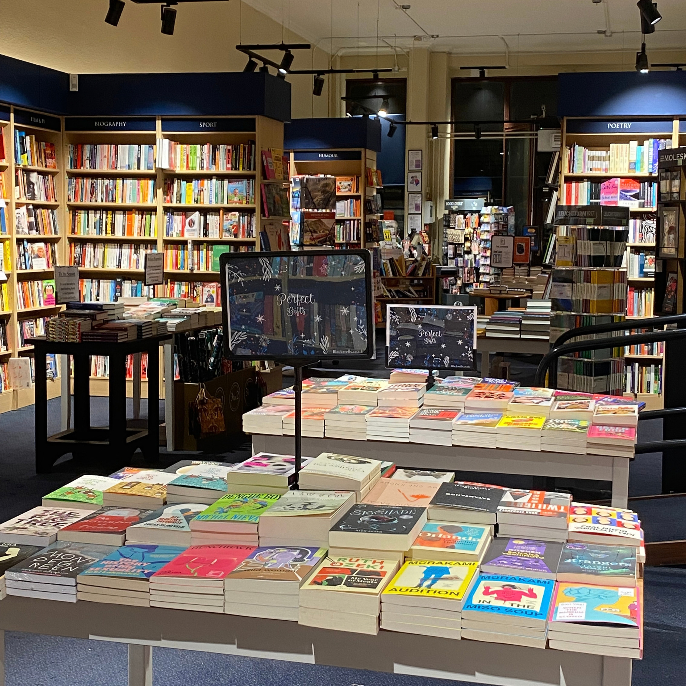 Image of a Waterstones bookshop, with tables in the foreground and bookshelves in the background filled with books. Imagining what a Borders bookshop might have looked like previously.